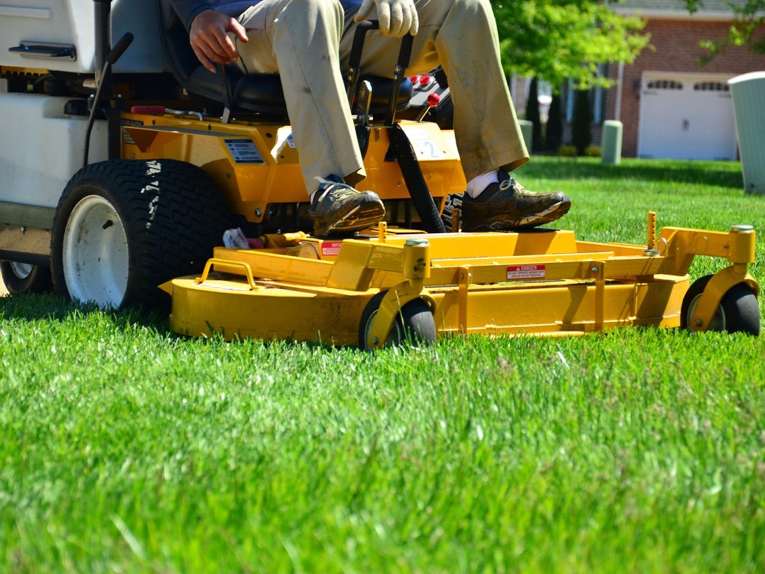 Adonai Lawns crew member operating a commercial mower