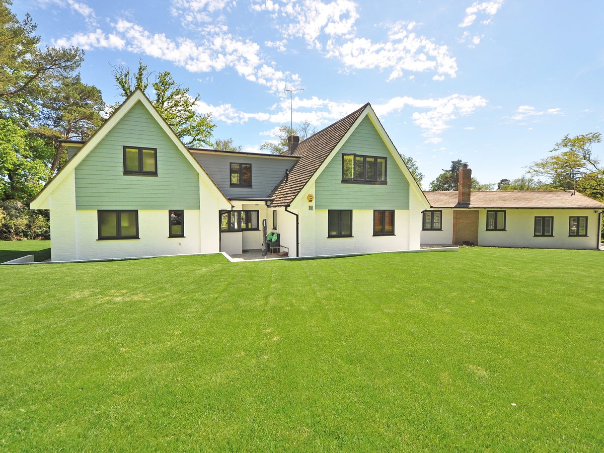 Full, healthy lawn wrapping a home after renovation